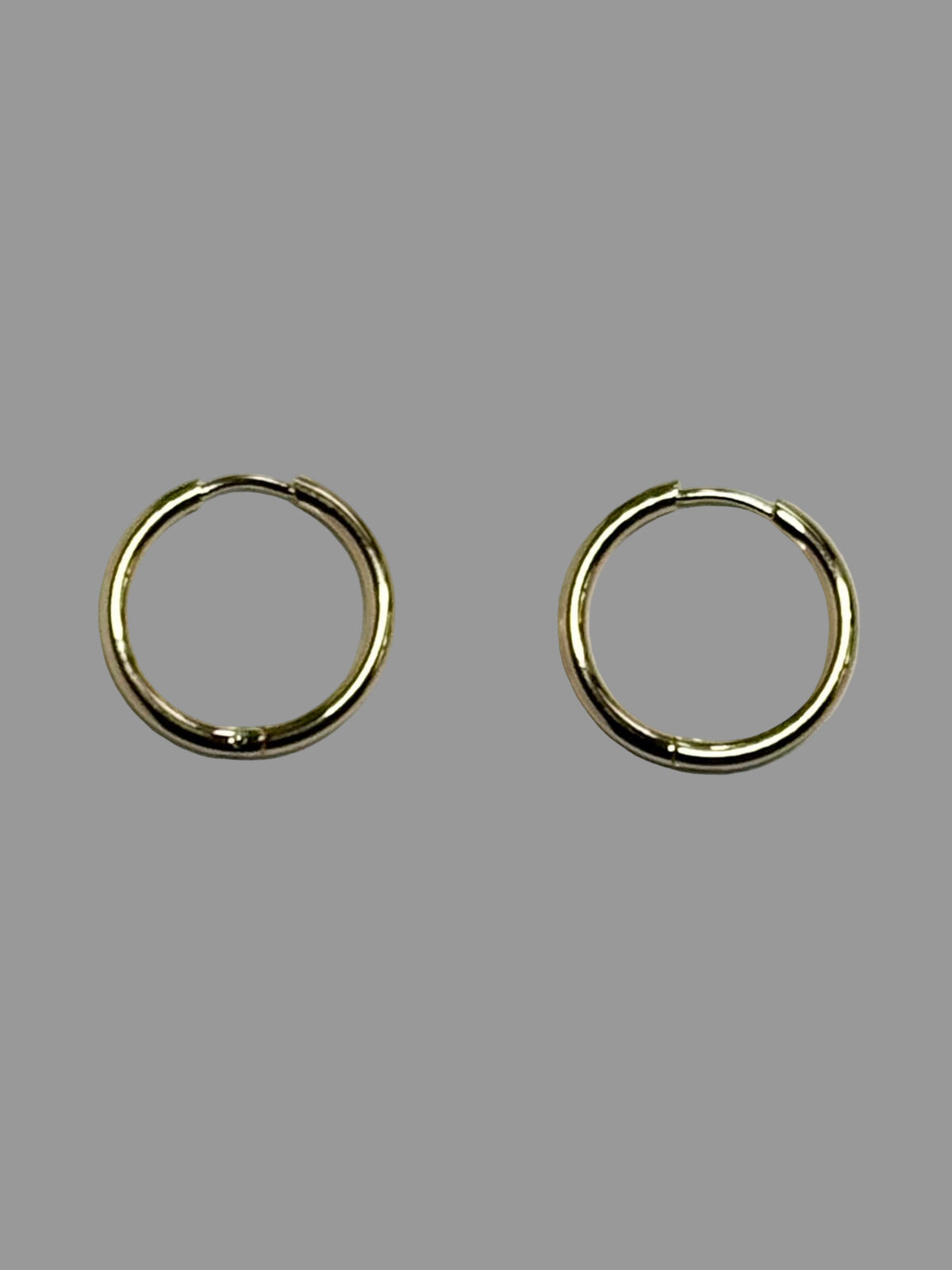 Gold hoop earrings on a light gray background