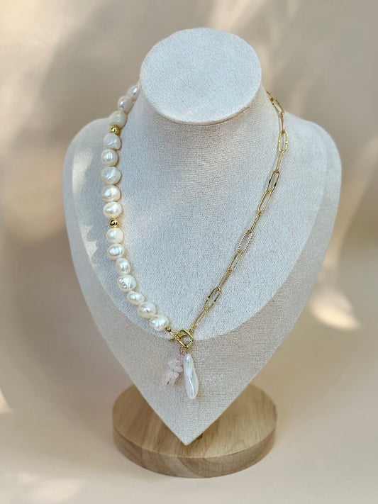 Pearl necklace with a gold chain on a white mannequin bust.