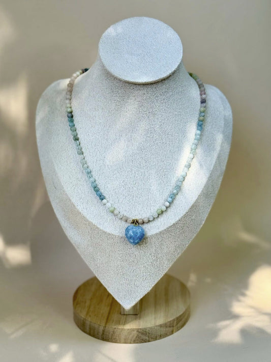 Necklace with blue pendant on a white mannequin bust with wooden base