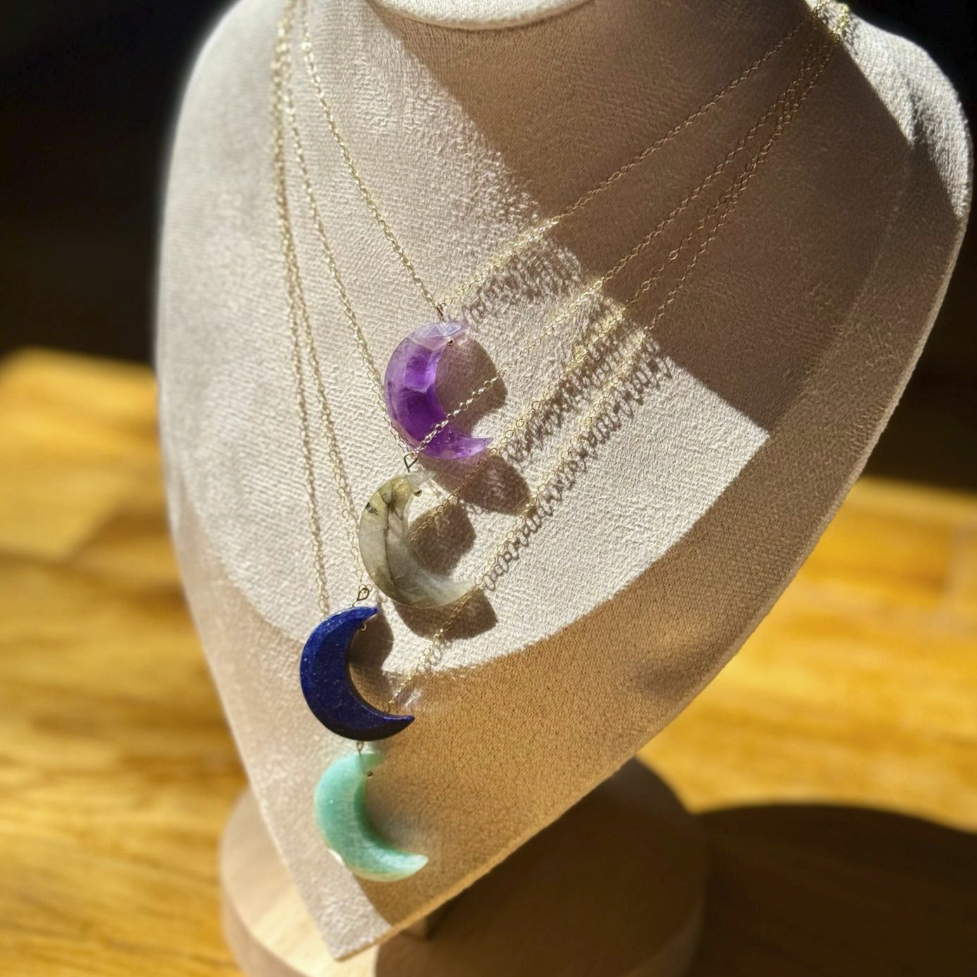 Necklace with colorful pendants on a mannequin bust against a dark background